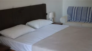 Letto matrimoniale con copriletto, cuscini e lenzuola bianche