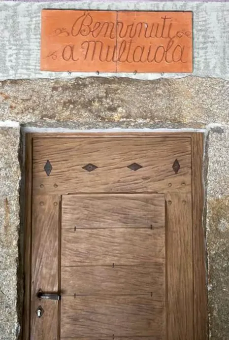 particolare di una delle porte di ingresso a Multaiola, in legno massiccio con una cornice in granito bocciardato