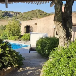 vialetto di un giardino coperto da una pergola in legno, che porta a una piscina