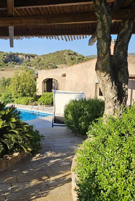vialetto di un giardino coperto da una pergola in legno, che porta a una piscina